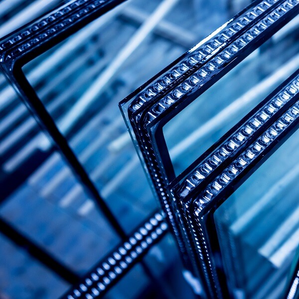 Close-up of stacked layers of multi-pane security or laminated glass, representing various bullet-resistant materials used in building construction.
