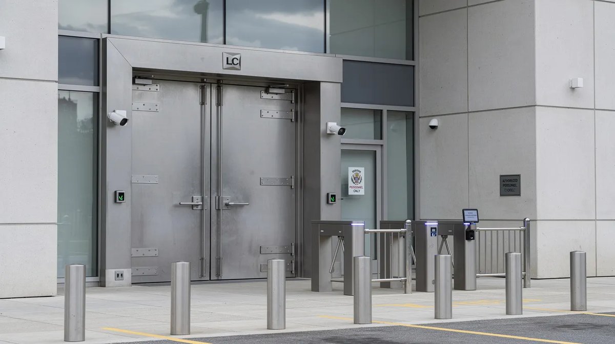 The exterior of a secure government building with heavy, forced entry resistant doors that have a welded door core material and steel edge construction. The controlled access point emphasizes security and protection, ensuring durability against potential threats.